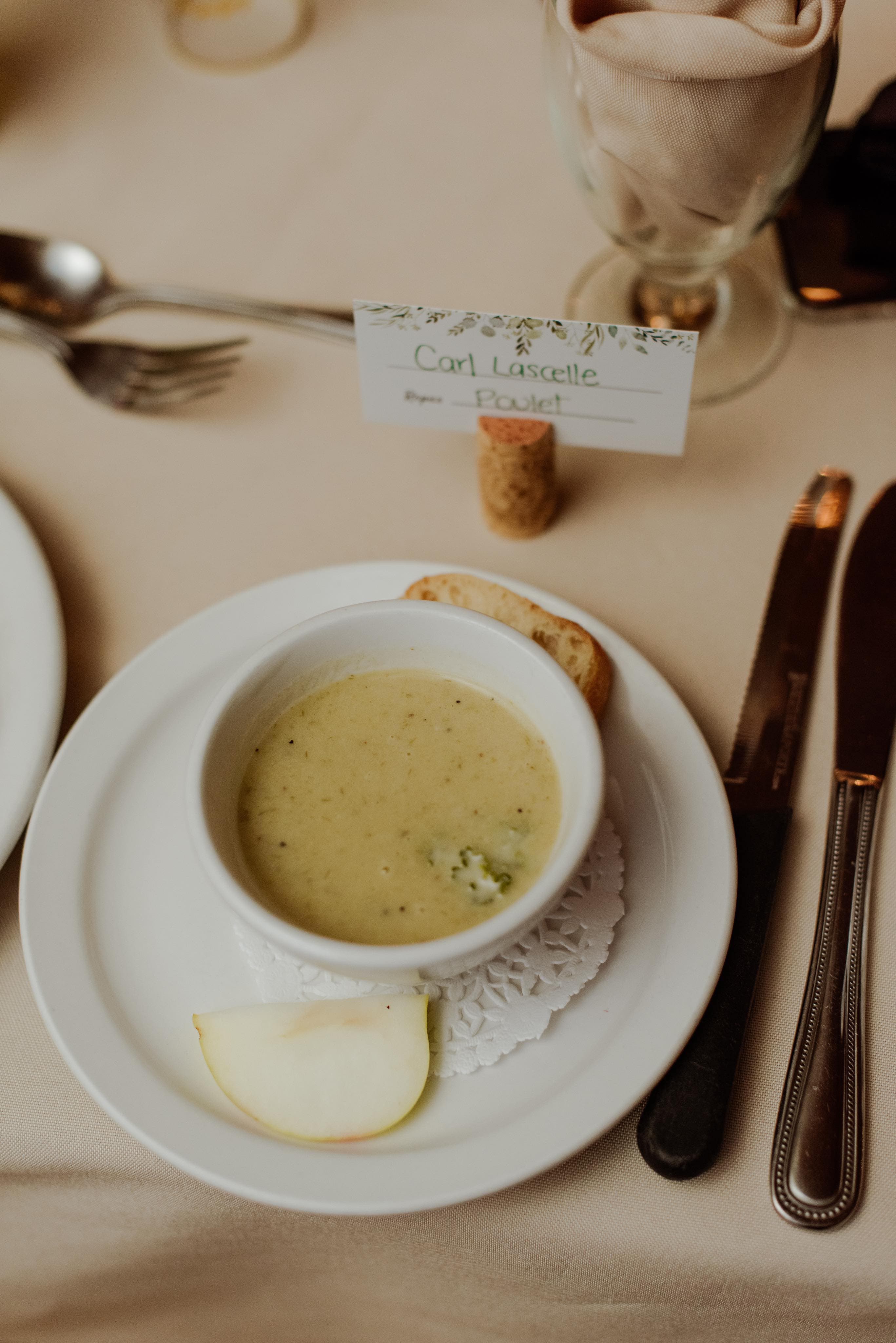 Potage servi à table avec carte de placement calligraphiée